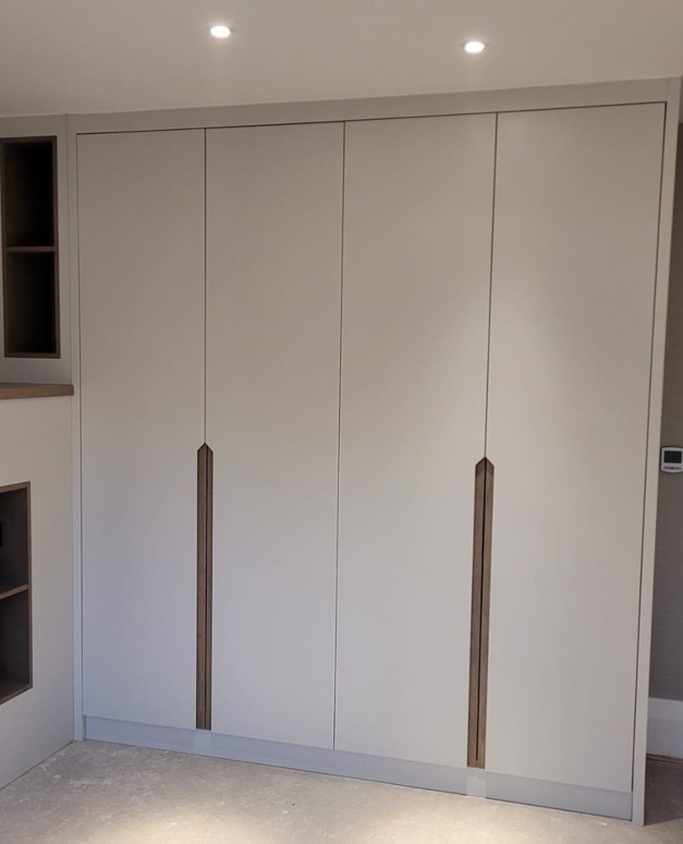 Modern white fitted wardrobe with wooden bar handles