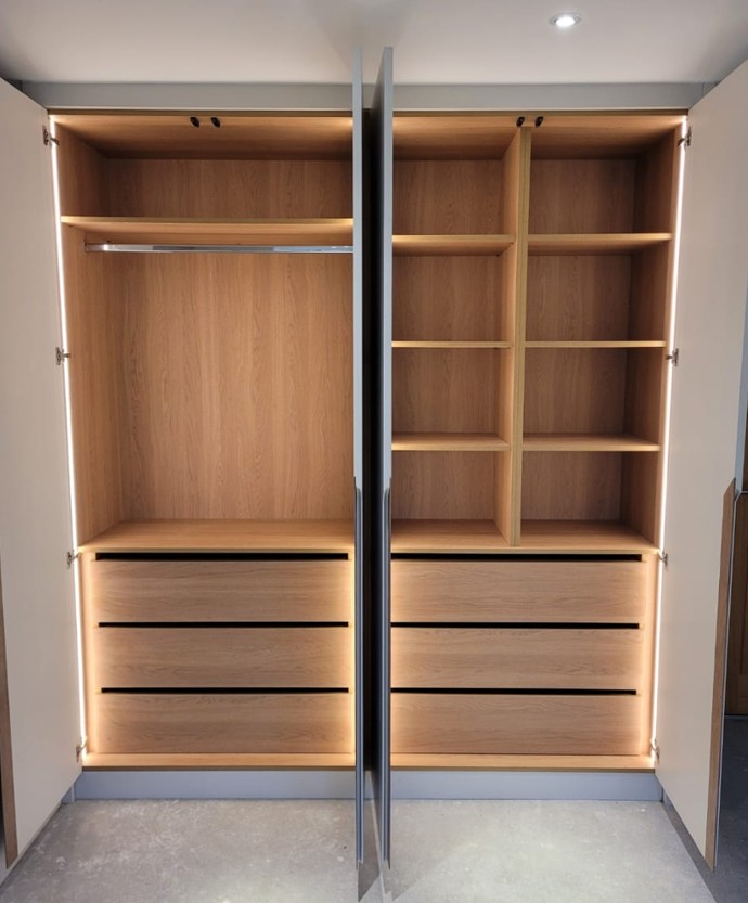 Wardrobe interior with integrated LED lighting, hanging rail, shelving and drawer storage