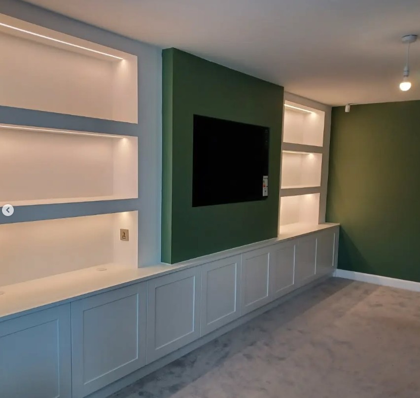 Media wall with green feature panel and floating cabinetry
