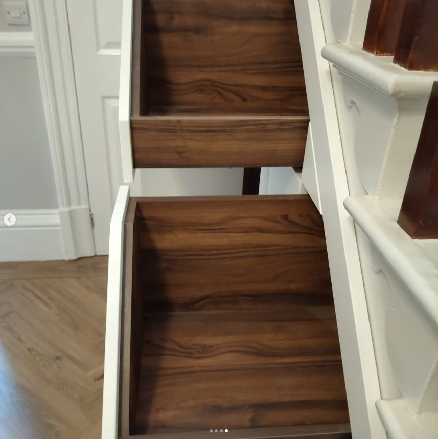 Detail of custom walnut drawer storage under stairs