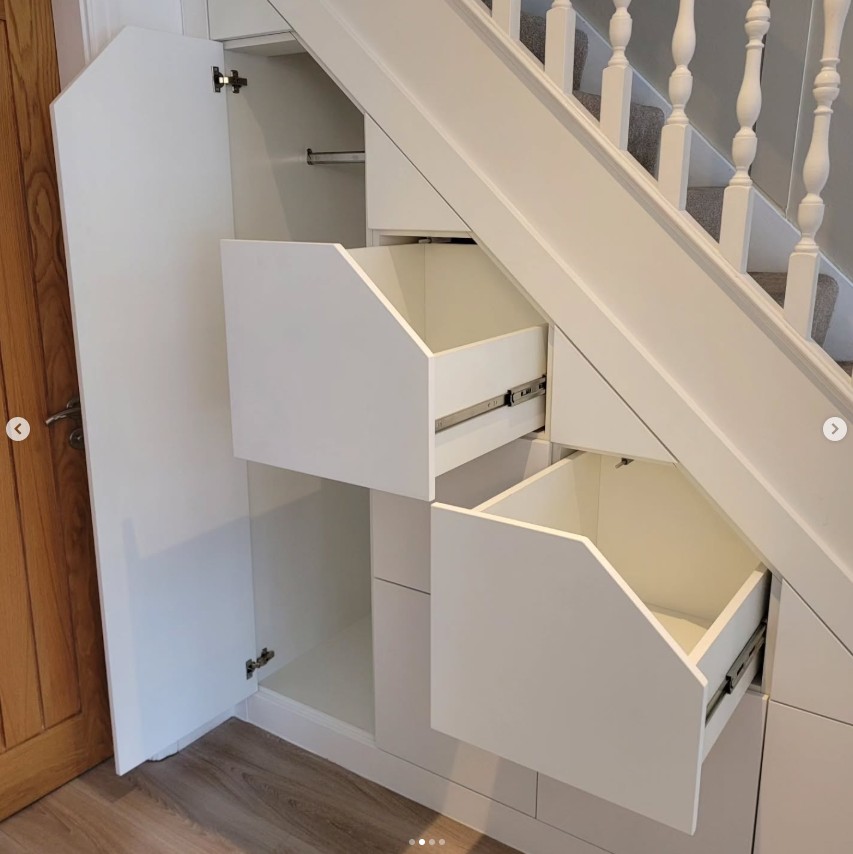 Under stairs storage showing angled drawer system and cupboard access